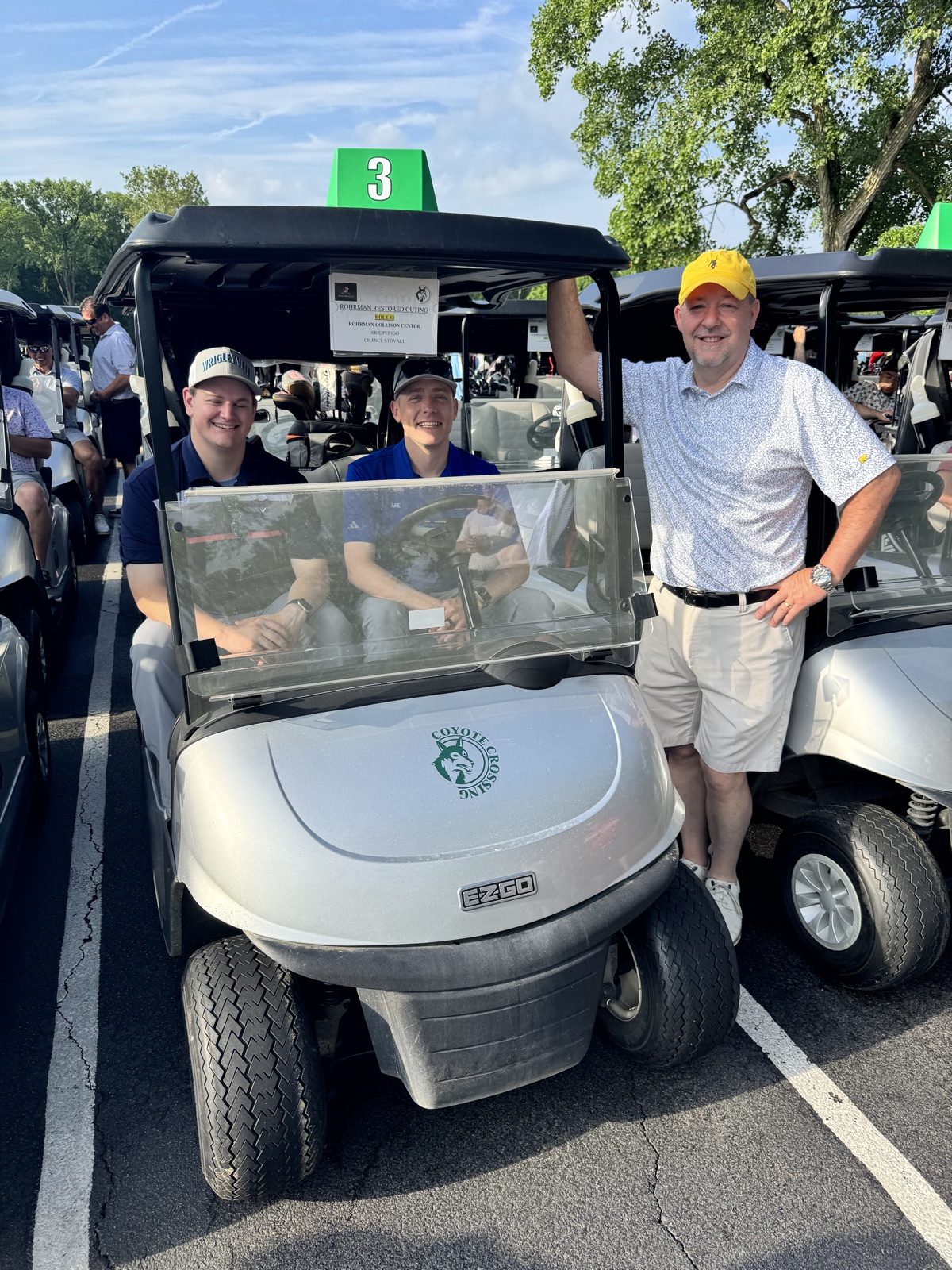 Chance Stovall, Arie Perigo, and Mark Vandeveer of Bob Rohrman Collision Repair Center with a Coyote Crossing golf cart at the Restored golf outing in West Lafayette, Indiana