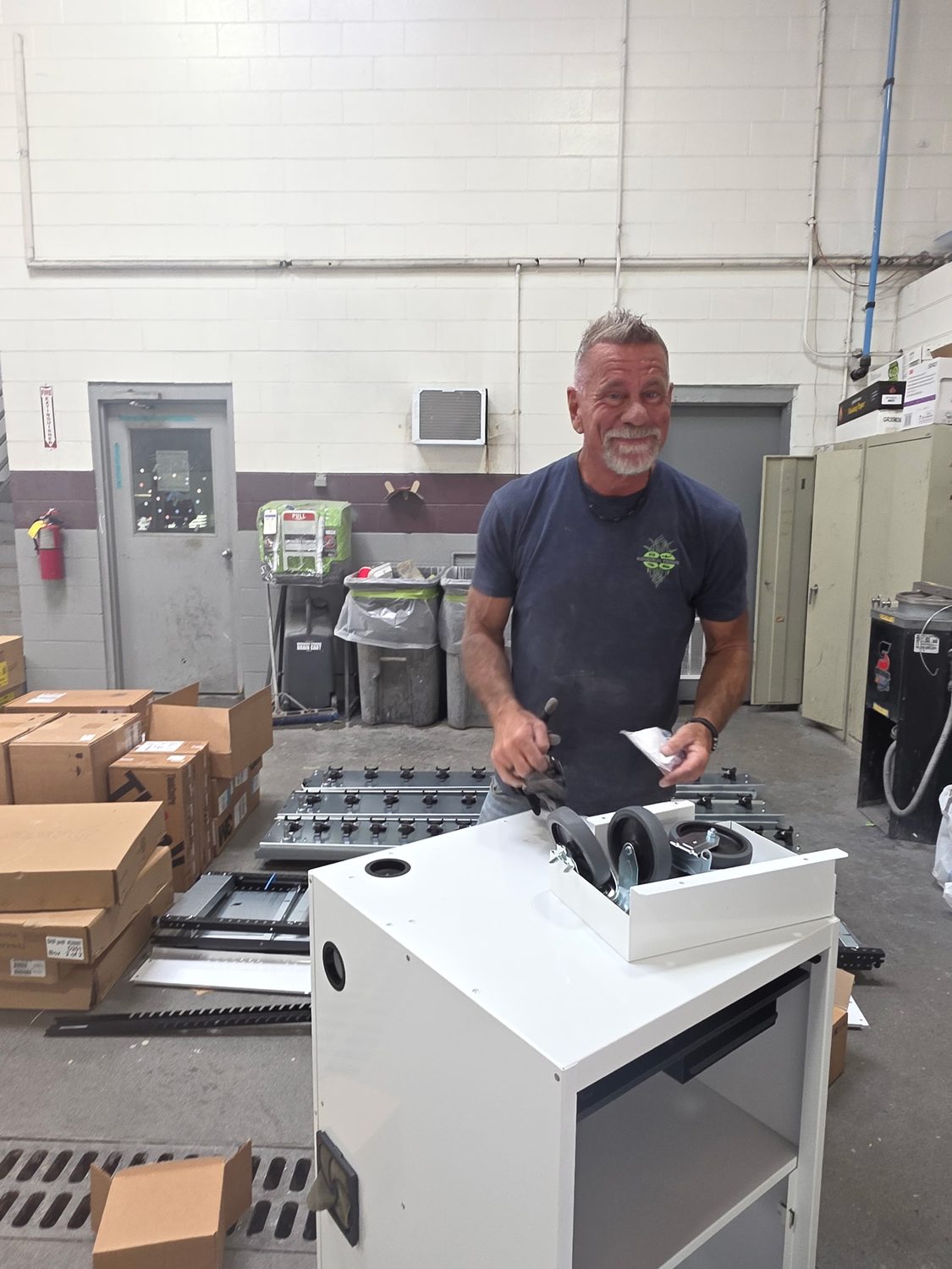 Dave from Industrial Finishes & Systems assembling the new paint mixing cabinet during the mixing room remodel at Bob Rohrman Collision Repair Center in Lafayette, Indiana