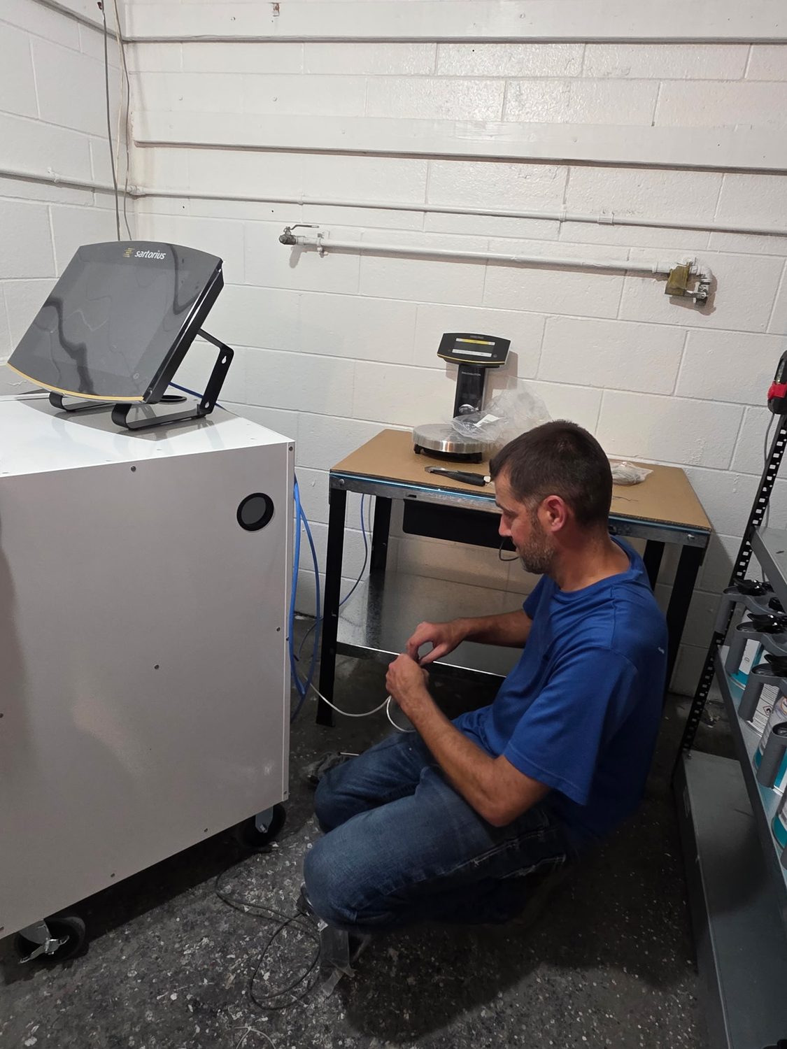 Technician installing the new Sartorius paint mixing scale and cabinet during the mixing room remodel at Bob Rohrman Collision, Lafayette Indiana