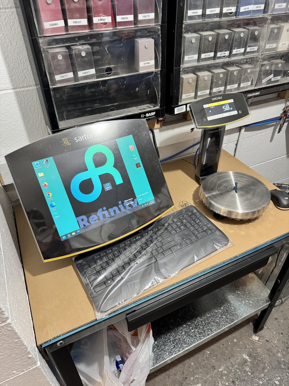 New Sartorius precision paint mixing scale with a stainless weighing pan and digital readout next to the BASF toner racks at Bob Rohrman Collision Repair Center in Lafayette, Indiana