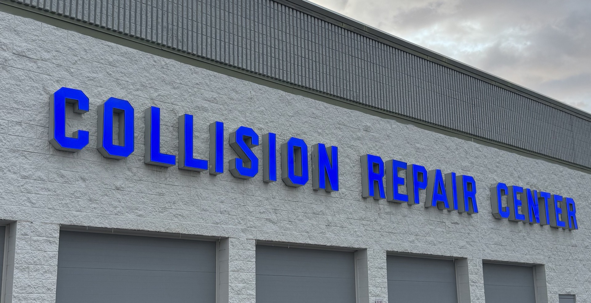 New bright blue illuminated COLLISION REPAIR CENTER channel-letter sign on the Bob Rohrman Collision Repair Center building in Lafayette, Indiana