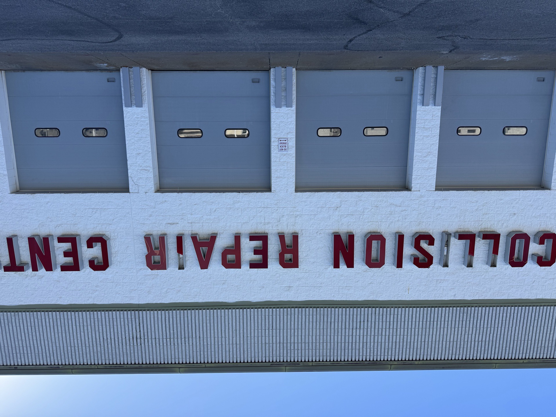 Old red-letter COLLISION REPAIR CENTER sign on the Bob Rohrman Collision Repair Center building before the 2026 upgrade